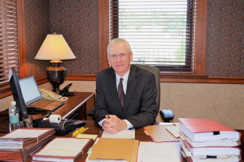 Dennis sitting at his desk.